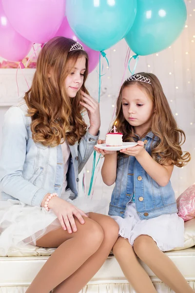 Duas meninas bonitas com bolo de aniversário e balões — Fotografia de Stock