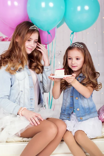 Two pretty sisters with birthday cake — Stock Photo, Image