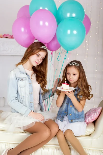 Two happy girls with birthday cake and balloons — Stock Photo, Image