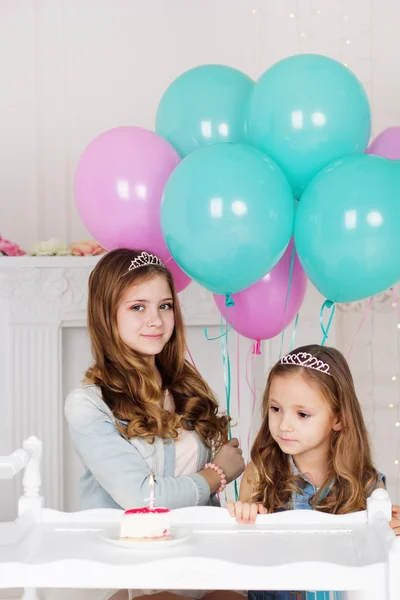 Two sisters are celebrating birthday with cake — Stock Photo, Image