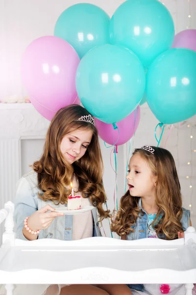 Dua saudara perempuan dengan kue dan balon, konsep ulang tahun — Stok Foto