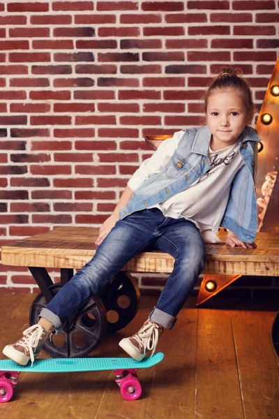 Pretty child girl with blue skateboard in studio — Stock Photo, Image
