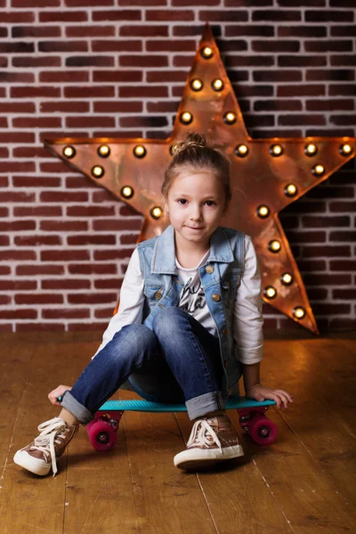 Pretty child girl with blue skateboard at home — Stock Photo, Image