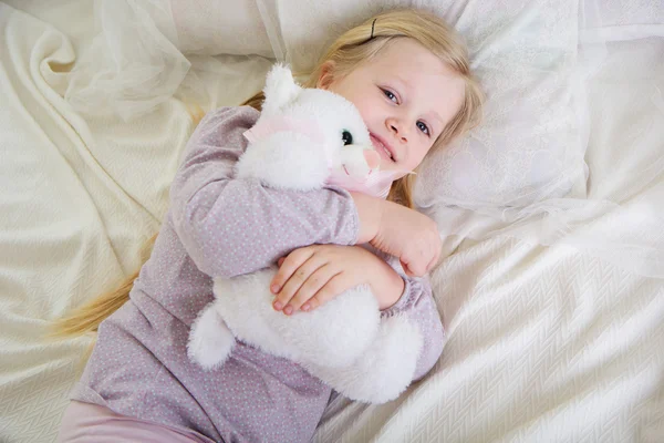 Mädchen im Bett mit Teddybär — Stockfoto