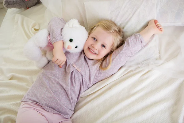 Mädchen im Bett mit Teddybär — Stockfoto