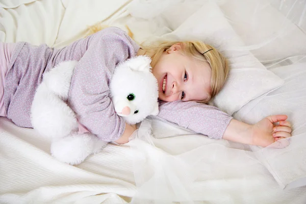 Mädchen im Bett mit weißem Teddybär — Stockfoto