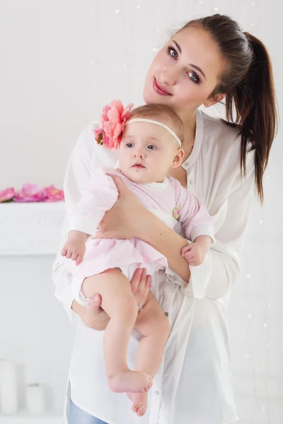 Happy mother holding her baby girl in studio — Stock Photo, Image