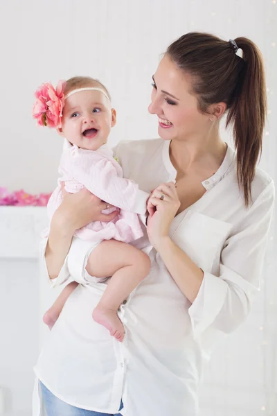 Happy mother holding her baby girl at home — Stock Photo, Image