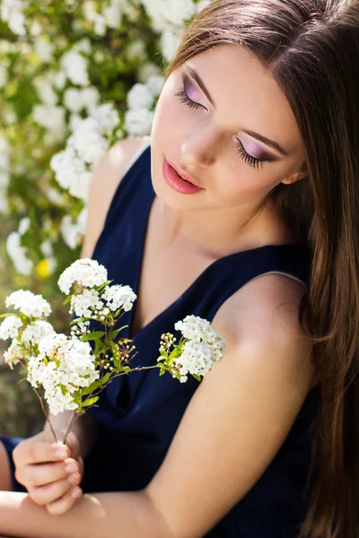 Jolie jeune fille souriante avec des fleurs blanches ourdoors — Photo