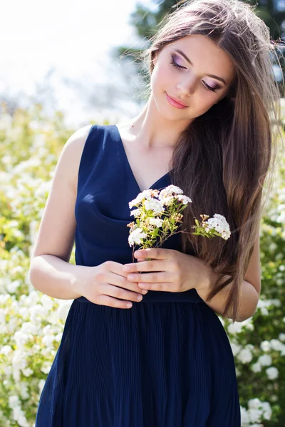 Hübsches Mädchen mit weißen Blumen auf der Natur — Stockfoto