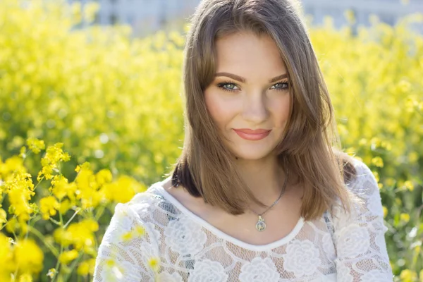 Linda chica en el campo con flores amarillas —  Fotos de Stock