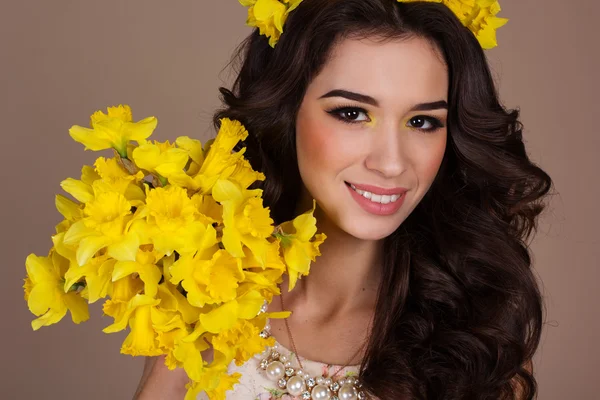 Söt leende flicka med gula blommor — Stockfoto