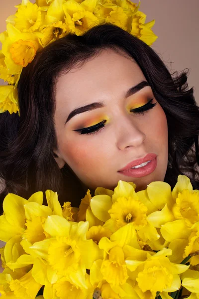 Frau mit modischem Make-up und gelben Blumen — Stockfoto