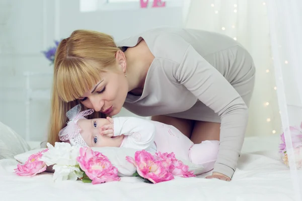 Mother is kissing her little daughter — Stock Photo, Image