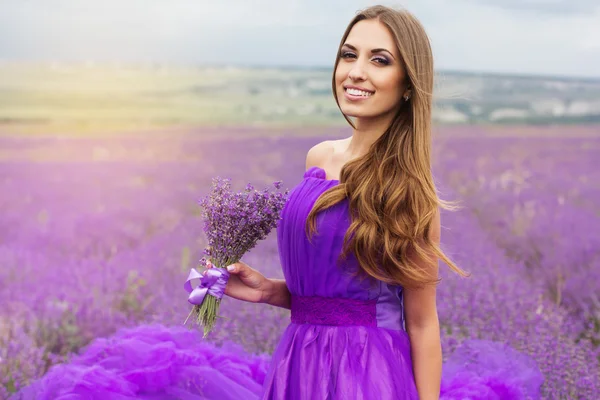 Chica sonriente con ramo de flores de lavanda — Foto de Stock