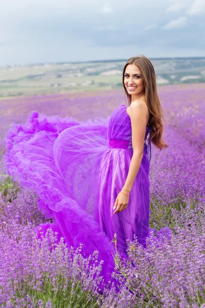 Mulher está vestindo vestido de moda em flores de lavanda — Fotografia de Stock