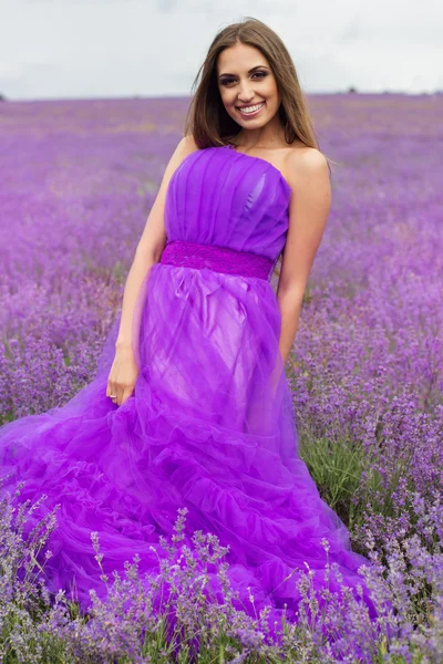 Flickan bär lila klänning på lavendel fält — Stockfoto
