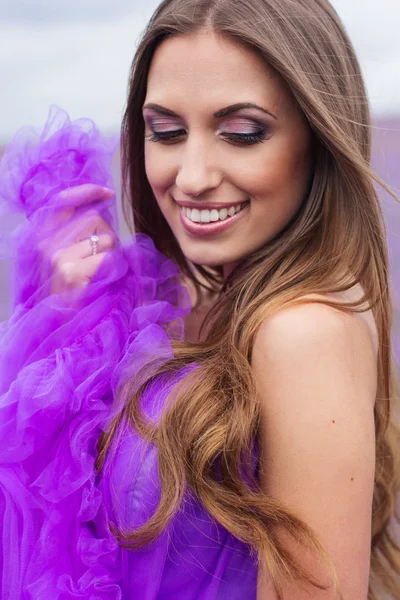 Mulher sorridente está usando vestido em flores de lavanda — Fotografia de Stock