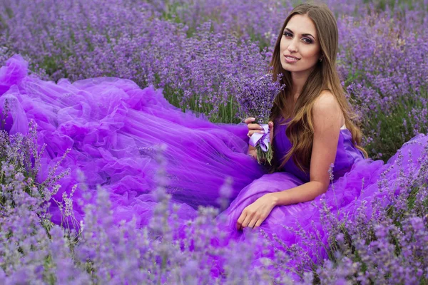 Chica de la moda está sentado en el campo de lavanda — Foto de Stock