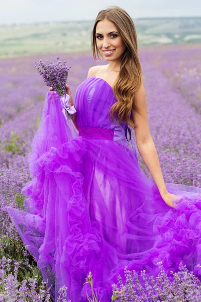Lila dröm, flicka i ett fält av lavendel blommor — Stockfoto