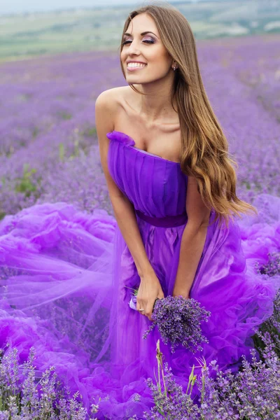 Lycklig kvinna i lila klänning på lavendelfält — Stockfoto