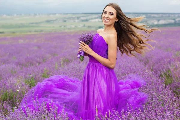 Gelukkige vrouw met haar op lavendelvelden vliegende — Stockfoto