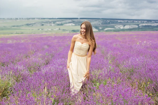 Chica está caminando en el campo de lavanda — Foto de Stock