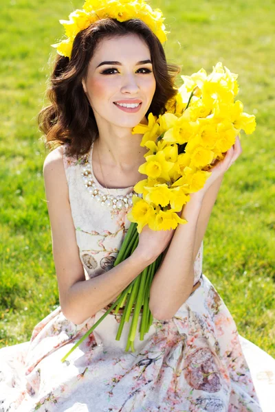Onnellinen hymyilevä tyttö keltaisia kukkia — kuvapankkivalokuva