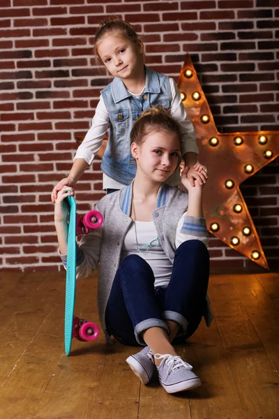 Two girls with skateboard in studio — Stock Photo, Image