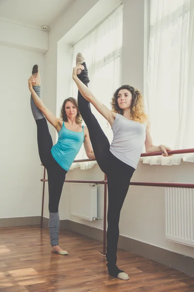 Dwie kobiety pasuje robienie ćwiczeń baletu — Zdjęcie stockowe