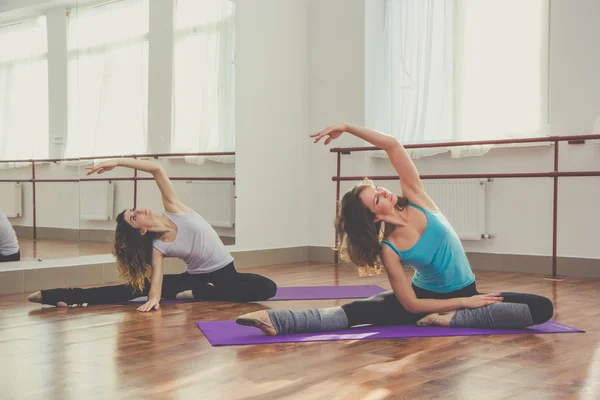Dos mujeres delgadas están haciendo ejercicio de estiramiento —  Fotos de Stock