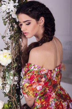 Güzel kız çiçek salıncakta oturuyor