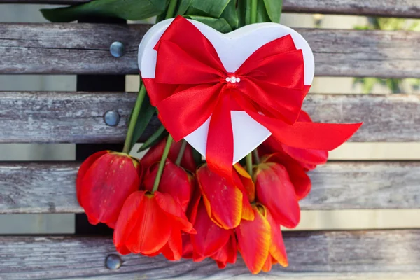 Red tulip flowers and gift box on wooden table — Stock Photo, Image