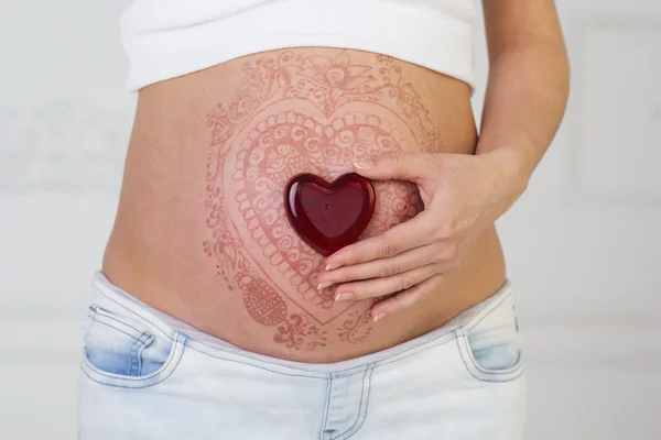 Kvinnans gravid mage med henna tatuering — Stockfoto