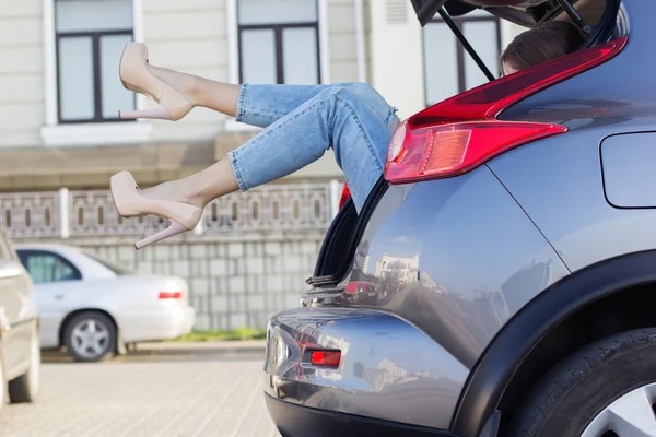 Meisjes benen in de auto kofferbak is het dragen van hakken — Stockfoto