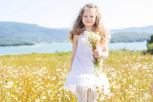 Linda niña sonriente en el campo de manzanilla —  Fotos de Stock