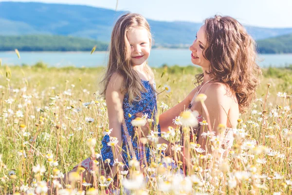 Mother and child girl in chamomile field — Stock Photo, Image