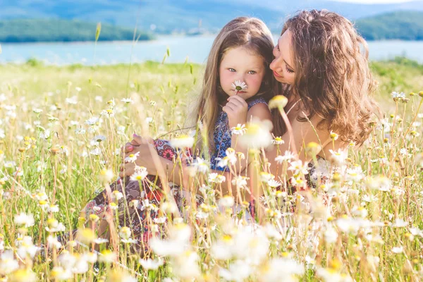 Mother and daughter in chamomile field — Stock Photo, Image