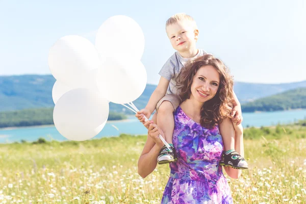 Mother with son are having fun in chamomile field — Stock Photo, Image