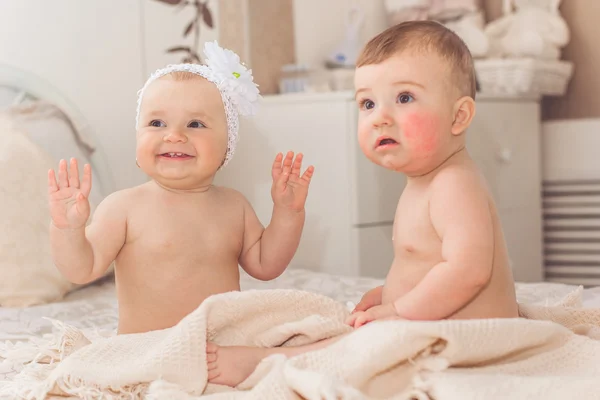 Two cute babies boy and girl are playing on bed — Stock Photo, Image