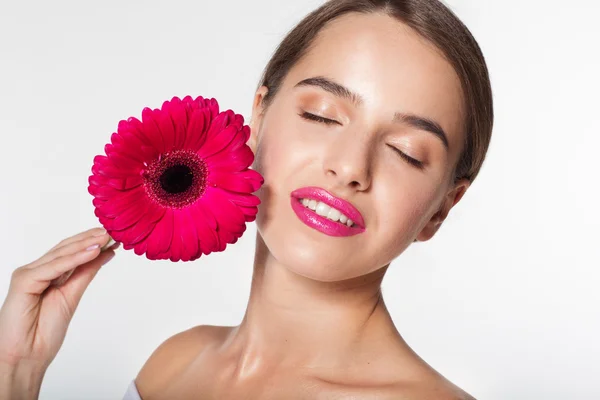 Vacker flicka med gerbera blomma nära ansikte — Stockfoto