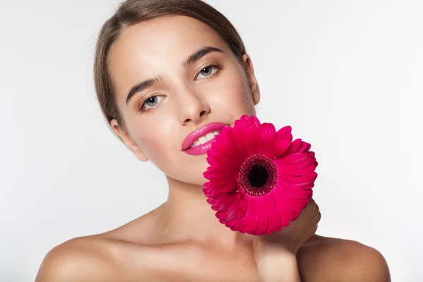 Vacker flicka med perfekt hud håller gerbera blomma — Stockfoto