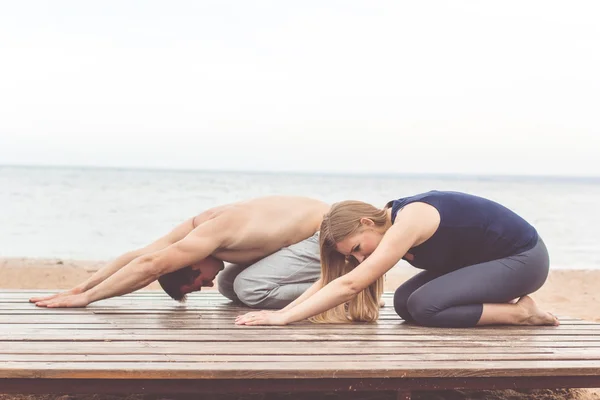 Couple are doing stretching at sea coast — Stock Photo, Image