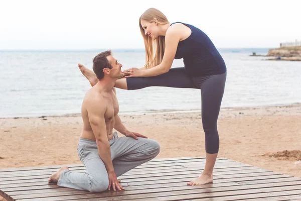 Pareja están haciendo deportes en la costa del mar —  Fotos de Stock