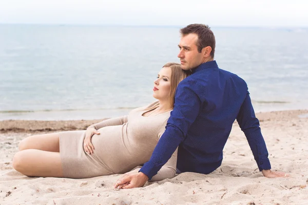 Άνδρας και γυναίκα έγκυος αναπαύονται στην παραλία — Φωτογραφία Αρχείου