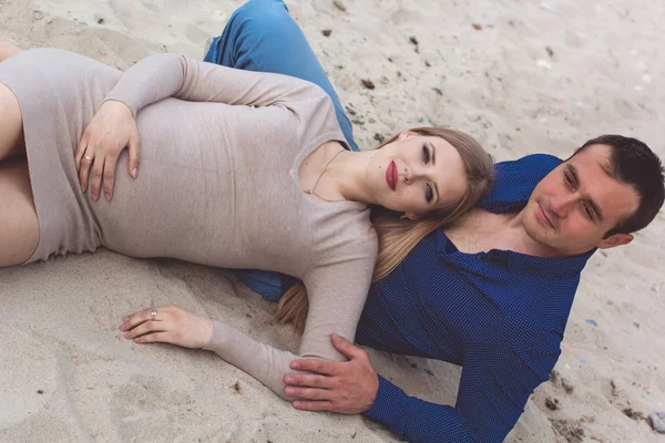 Hombre y mujer embarazada están descansando en la playa — Foto de Stock