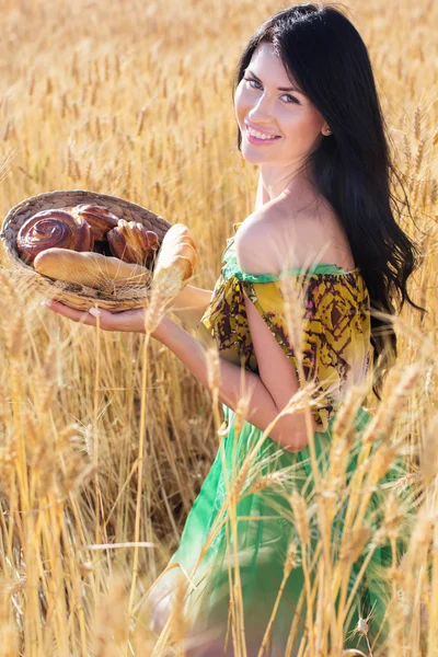 Jolie fille dans le champ de seigle avec panier de pain — Photo