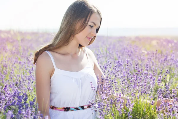 Adolescente chica está descansando en el campo púrpura de lavanda — Foto de Stock