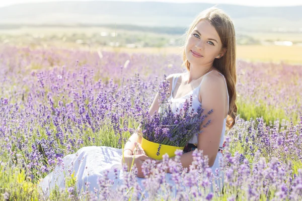 Chica está descansando en el campo púrpura de lavanda — Foto de Stock