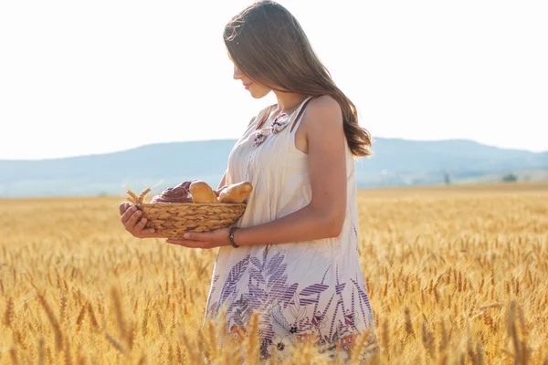 Fille dans le champ de seigle avec panier de petits pains et petits pains — Photo